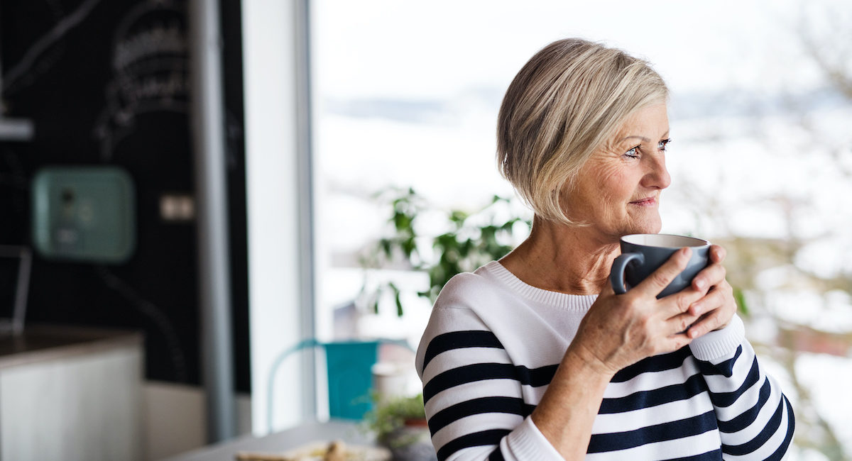 Senior woman holding a cup of coffee in the kitchen