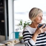 Senior woman holding a cup of coffee in the kitchen