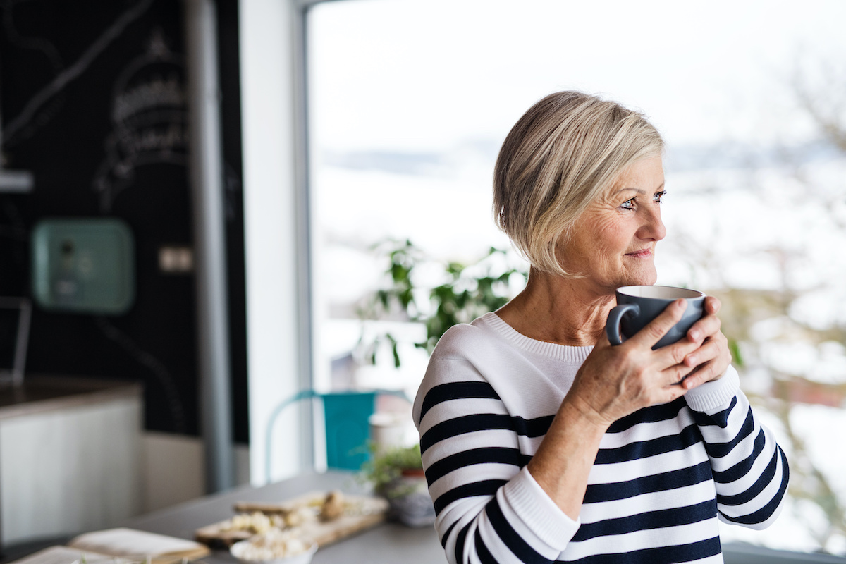 Senior woman holding a cup of coffee in the kitchen